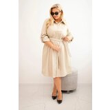 Kesi Plus Size women's dress made of eco-leather with a belt and collar beige Cene