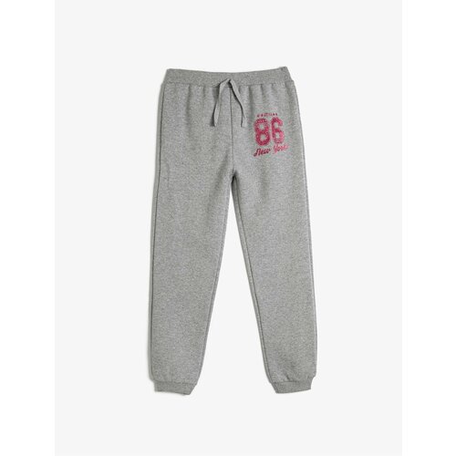 Koton Jogger Sweatpants with Tie Waist and Glitter Print Detail Cene